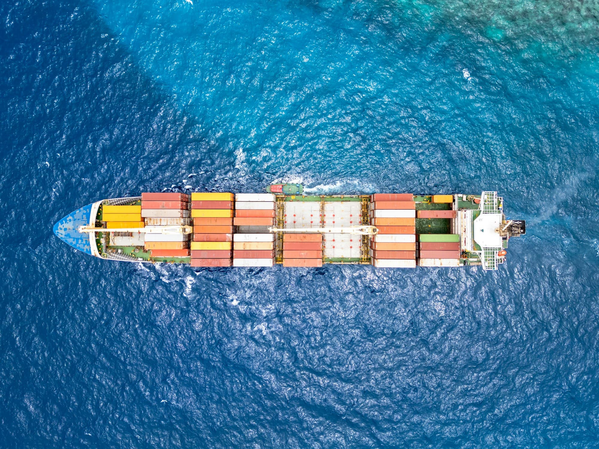 Vista aérea de navio cargueiro navegando em mar azul